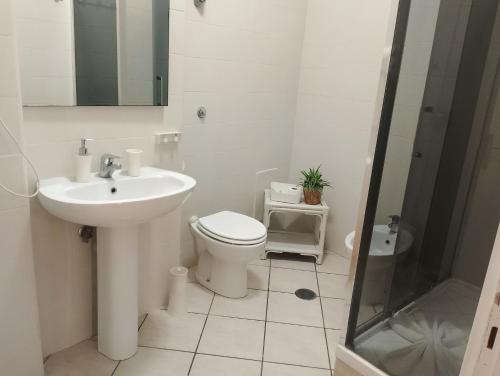 a white bathroom with a toilet and a sink at Dedalo affittacamere in Pompei