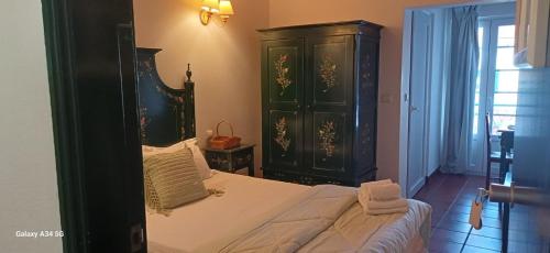 a bedroom with a large bed and a green cabinet at Mar e Sol in Vila Nova de Milfontes