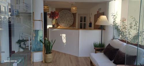 a living room with a white couch and a table at Mar e Sol in Vila Nova de Milfontes