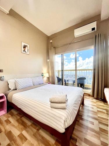 a bedroom with a large bed and a large window at Aizawl Hotel in Āīzawl