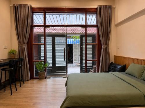 a bedroom with a bed and a desk and a window at B786 Airport Apartment in Ho Chi Minh City