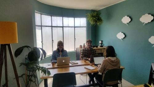 a group of people sitting at a table with laptops at Wanderlust District in Mexico City