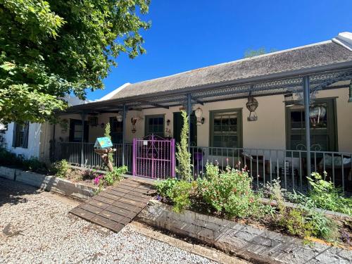 a house with a purple gate in front of it at Greyton Toad Hall in Greyton
