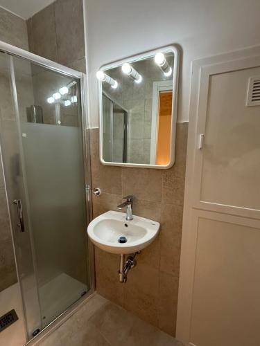 a bathroom with a sink and a shower and a mirror at Neptune Stone House in Molfetta
