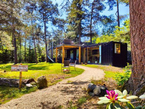 a small house in the woods with a gravel road at Skydeck Cabin met Jacuzzi & Rooftop in Holten