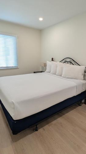 a large white bed in a room with a window at Rest Haven Motel in Los Angeles