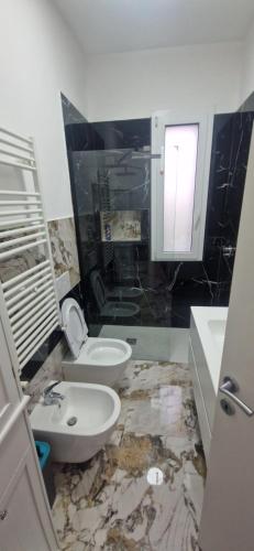 a bathroom with a white toilet and a sink at sunset suite con terrazza e barbecue in Imperia
