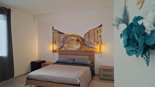 a bedroom with a bed and a painting on the wall at Salicornia Rooms in Comacchio