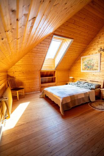 a bedroom with a bed in a wooden room at Amoliņi in Mērsrags