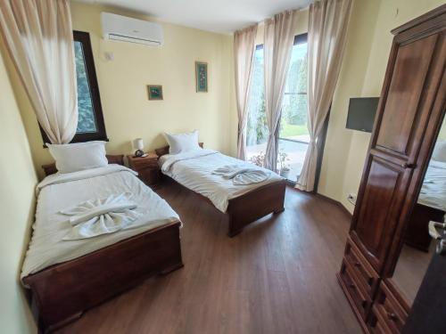 a hotel room with two beds and a window at Guesthouse Oasis-Shabla in Shabla