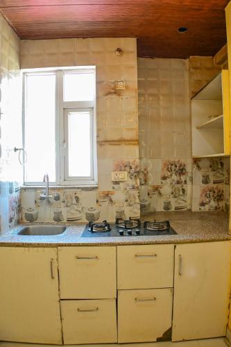 a kitchen with a sink and a stove and a window at Mahadev Mension Tapovan in Rishīkesh