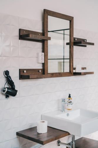 a bathroom with a white sink and a mirror at Casa Jardim di Sol in Praia