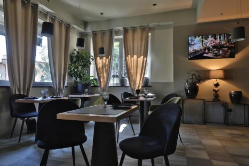 ein Restaurant mit Tischen, Stühlen und Fenstern in der Unterkunft Hotel Le Corderie in Triest