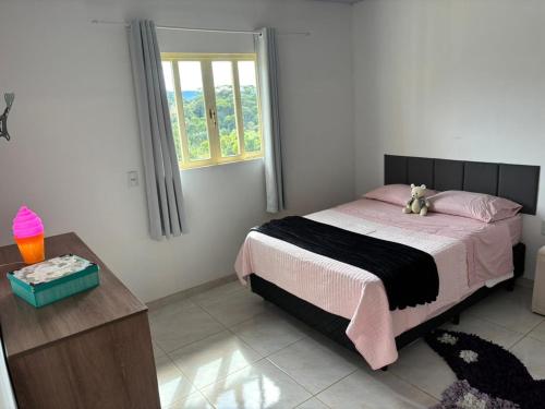 a bedroom with a bed with a teddy bear on it at Sitio em São Pedro de Alcantara in São Pedro de Alcântara