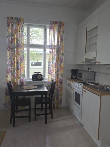 a kitchen with a table and chairs and a window at Huoneisto Majakka in Kokkola
