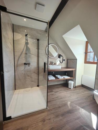 a bathroom with a shower with a glass door at Auberge Saint Jacques in Conques