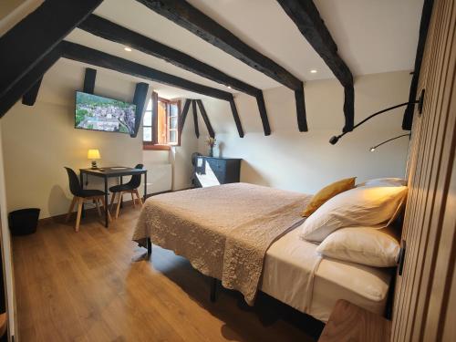 a bedroom with a bed and a table in it at Auberge Saint Jacques in Conques