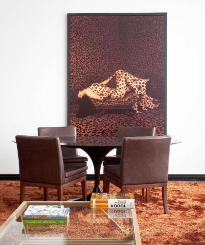 a table with two chairs and a leopard on a wall at Leonardo Boutique Hotel Tel Aviv in Tel Aviv