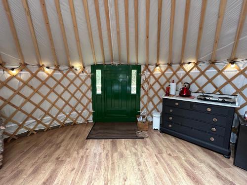 a room with a green door in a yurt at Jimmy's Yurt in Shenley