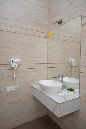 a bathroom with a sink and a mirror at Winners Hill Resort Walayar by Arcadia in Coimbatore