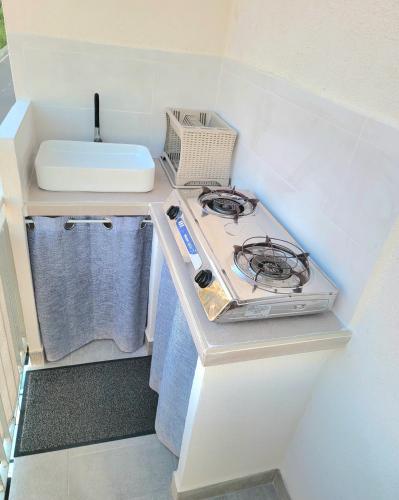 a small kitchen with a stove and a sink at Suite Ekaterina Sunsets 2 minuti dal mare in Brolo
