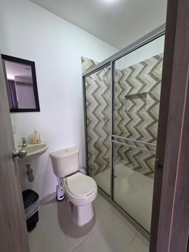a bathroom with a toilet and a glass shower at apartaestudio 304 tranquilo, cómodo y moderno in Tuluá