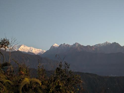 a mountain range with snow capped mountains in the distance at Mochilero B&B in Darjeeling