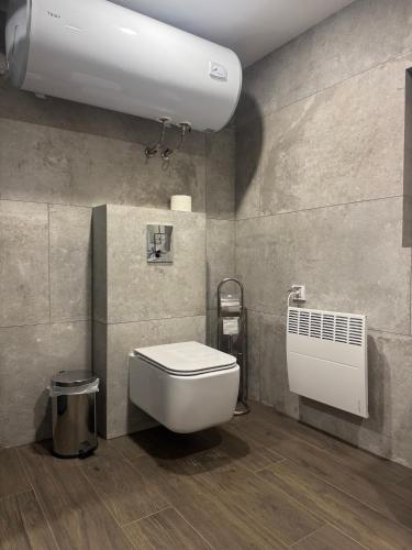 a bathroom with a white toilet and a radiator at Villa Vera in Smilyan