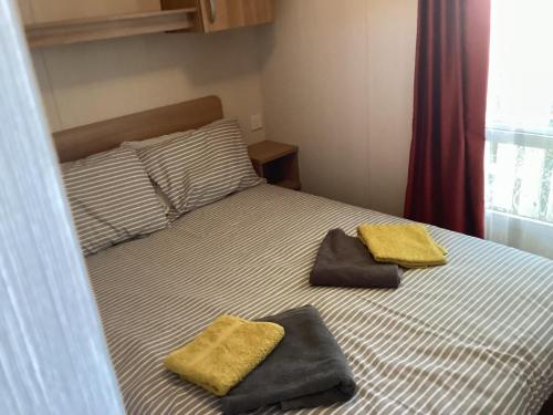 a bedroom with a bed with two towels on it at Cosy Costal Escape in Westward Ho