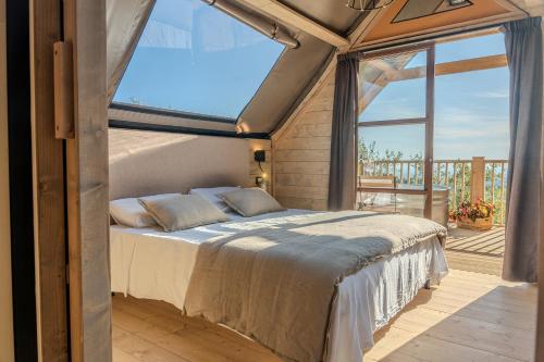 a bed in a room with a large window at Glamping Pagliaini in Riparbella