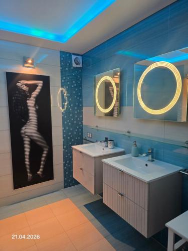 a bathroom with two sinks and two mirrors at PIOTROWSKi HOUSE in Ropica Górna