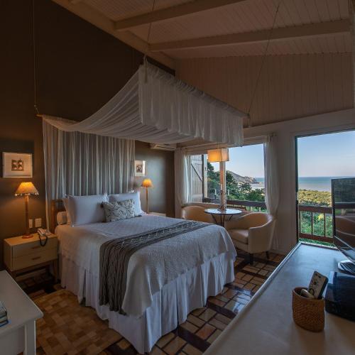 a bedroom with a bed and a view of the ocean at Pousada Quinta do Bucanero in Imbituba