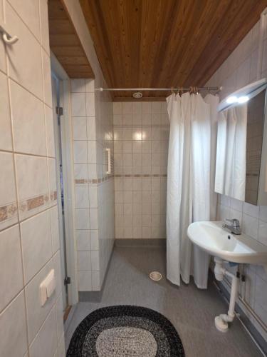 a bathroom with a sink and a shower at Huoneisto Majakka in Kokkola