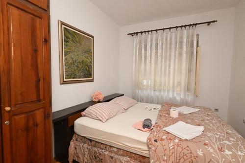 a small bedroom with a bed and a window at Hostel Holiday Cetinje in Cetinje
