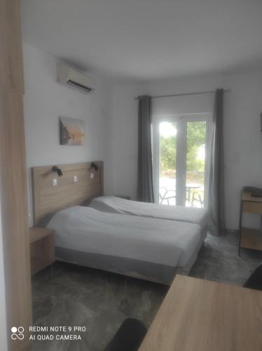 a bedroom with a bed and a window at Matina Studios in Kefalos