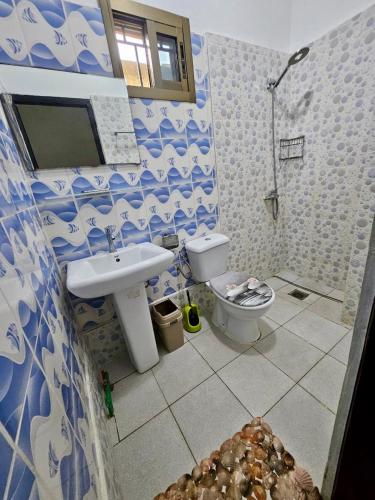 a blue and white bathroom with a toilet and a sink at Résidence Ephrata in Cocody