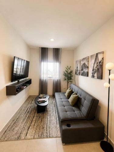 a living room with a couch and a tv at FIFA Monterrey Stay in Monterrey