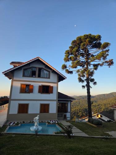 a white building with a tree in the background at The Winter Mountain Hotel in Monte Verde