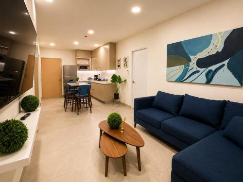 a living room with a blue couch and a table at Depto premium Valle Poniente UDEM Consulado 5px in Monterrey