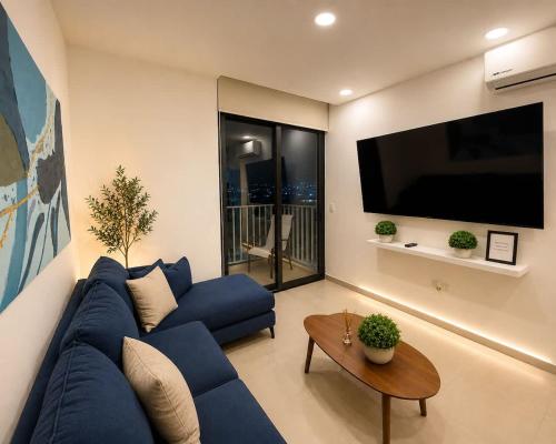 a living room with a blue couch and a flat screen tv at Depto premium Valle Poniente UDEM Consulado 5px in Monterrey