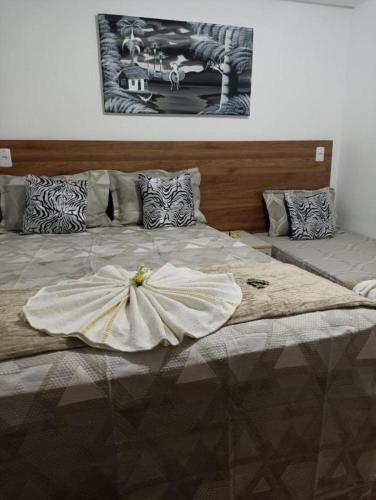 a large bed with a dress on top of it at Pousada Maceió é Massa Beira Mar in Maceió