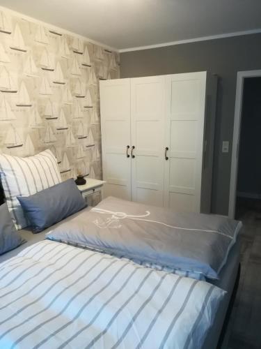 a bedroom with a large bed with white cabinets at Klein Erna (Apth.Holländerei) in Büsum