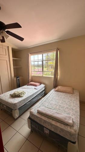 two beds in a room with a window at Hostal Sam in Managua