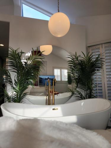 a large bathroom with a tub and two plants at Luxury Spa Townhome with Rooftop Ocean View Jacuzzi in Hermosa Beach