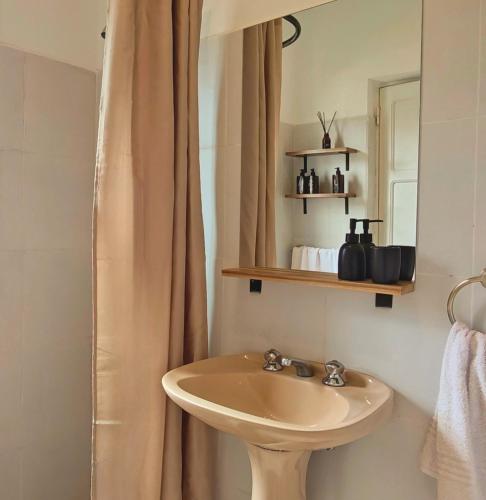 ein Badezimmer mit Waschbecken und Spiegel in der Unterkunft Hotel Aleph in Capilla del Monte