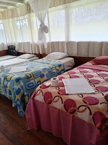 two beds sitting next to each other in a room at Amazon Lodge Iquitos in Iquitos