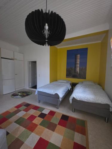 a bedroom with two beds and a chandelier at Huoneisto Majakka in Kokkola
