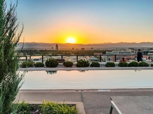 a view of the sunset from a building with a pool at Cherry Creek Rooftop Oasis in Denver