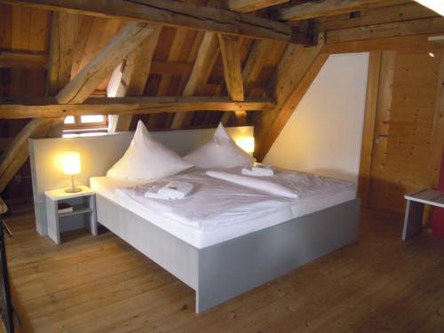 
a bed with a white bedspread and a wooden headboard at Tagungshaus Kloster Heiligkreuztal in Altheim
