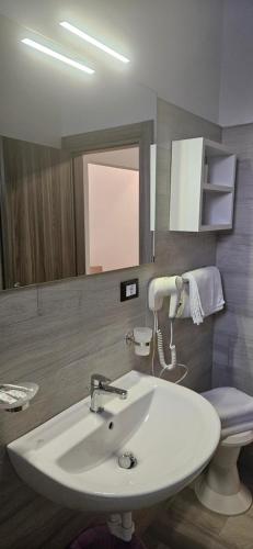 a bathroom with a white sink and a toilet at Hotel Sole in Eraclea Mare